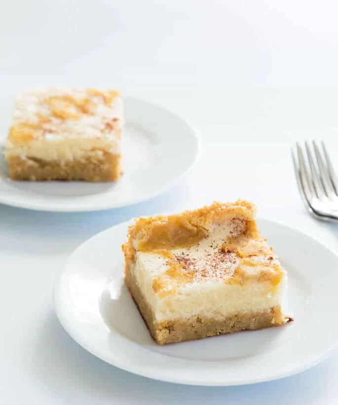 2 white plates with a piece of apple custard cake on them 