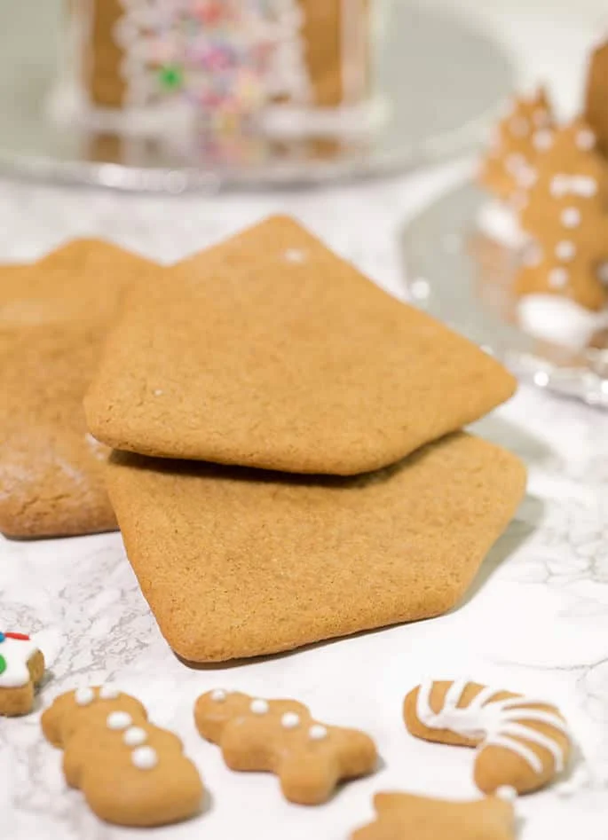 3 house shaped gingerbread cookies on marble surface