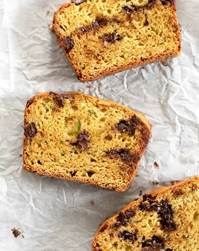 3 Slices of Gluten free zucchini bread laying on parchment.