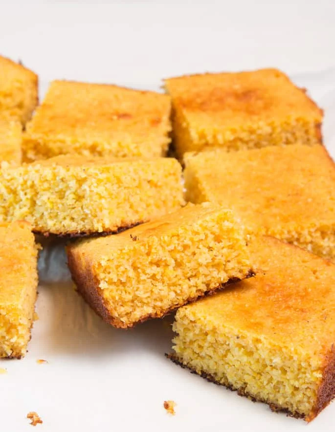 8 pieces of cornbread on a white surface 