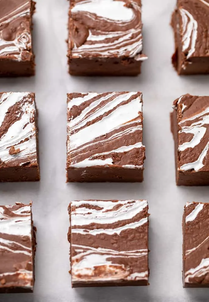 9 square pieces of fudge evenly spaced with white swirls on top on white paper
