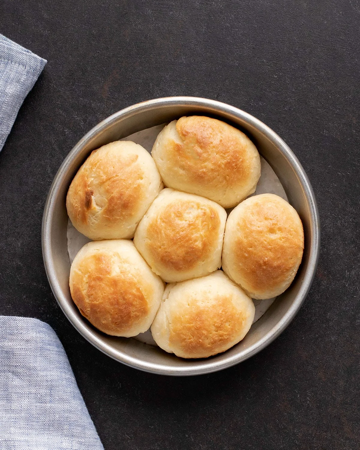 A baking pan with six rolls just out of the oven. 