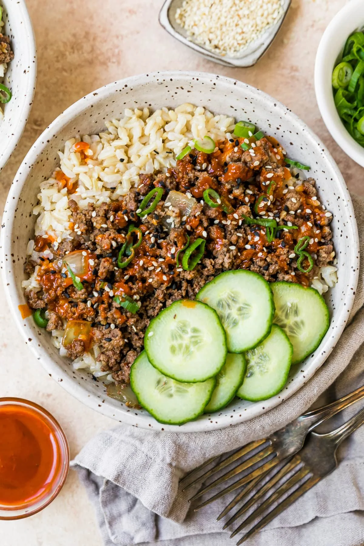 A bowl filled with homemade Korean beef, rice and cucumbers.