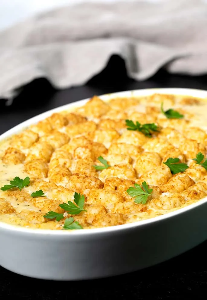 A casserole dish with tater tots and parsley