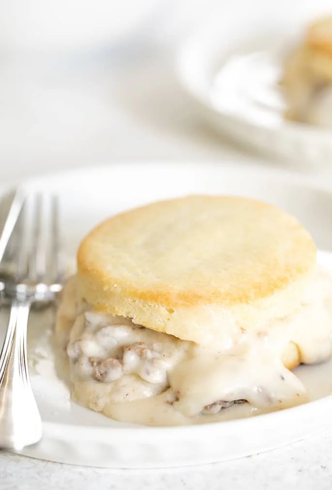 A close up of a finished biscuit on a plate with a fork.