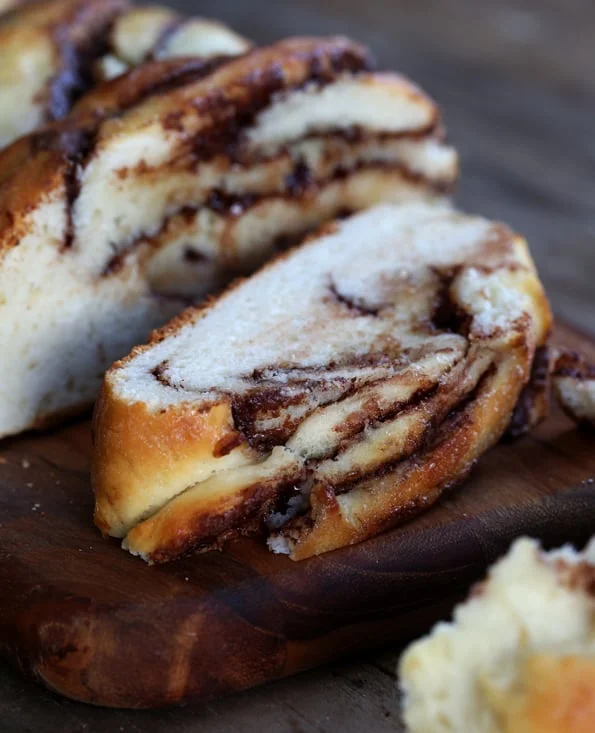A close up of a piece of Nutella bread on wooden surface