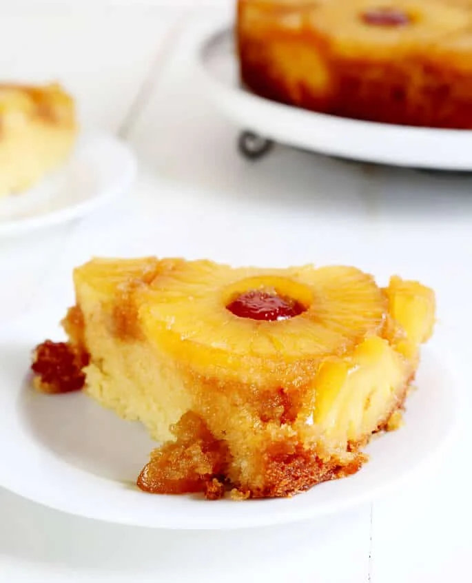 A close up of a piece of pineapple upside down cake on a plate