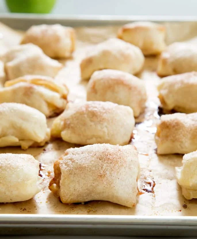A close up of apple dumplings on brown parchment paper