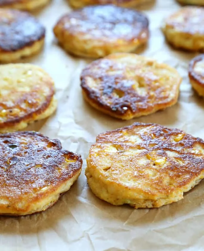 A close up of corn cakes on parchment paper