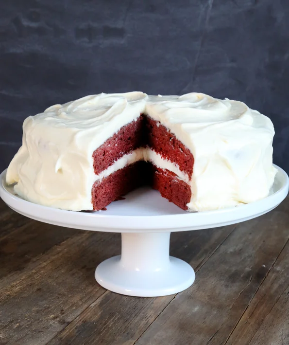 A close up of inside of red velvet cake on white cake stand 