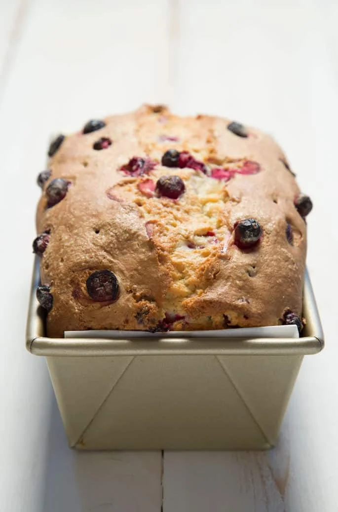 A close up of the top of the cranberry bread in a loaf pan.