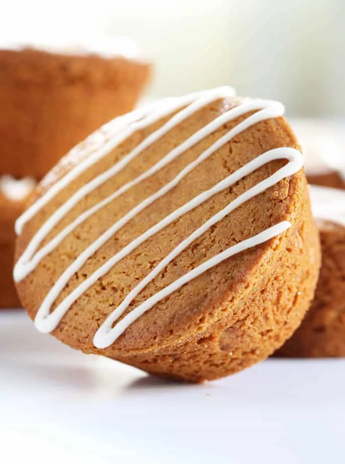 A lose up of a gingerbread muffin on its side on white surface 