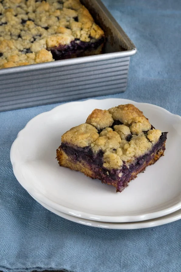 A piece of blueberry buckle on a white plate.