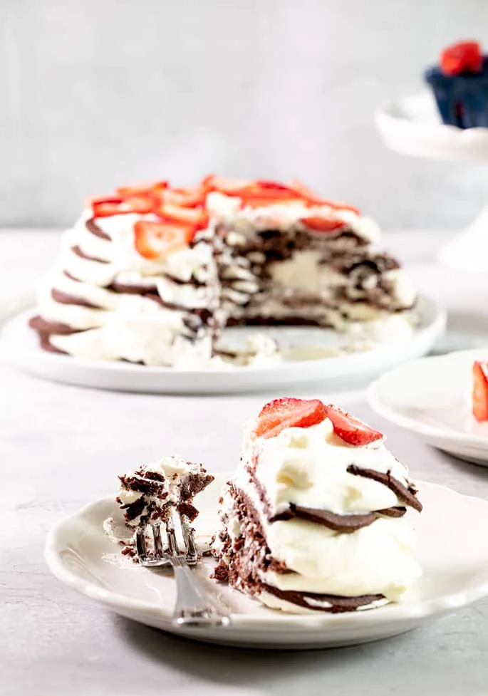 A piece of chocolate wafer cookie icebox cake on a small plate with a fork