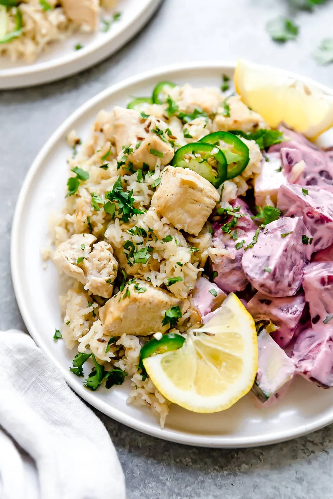 A plate of chicken pulao with lemon wedges