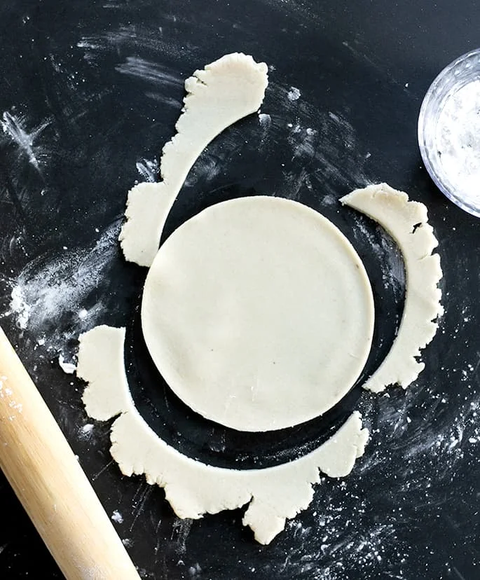 A rolling pin, a Paleo tortilla cut out of raw dough