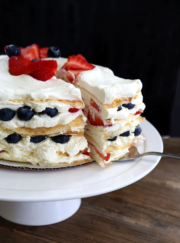 A slice of crepes cake being taken from. entire cake