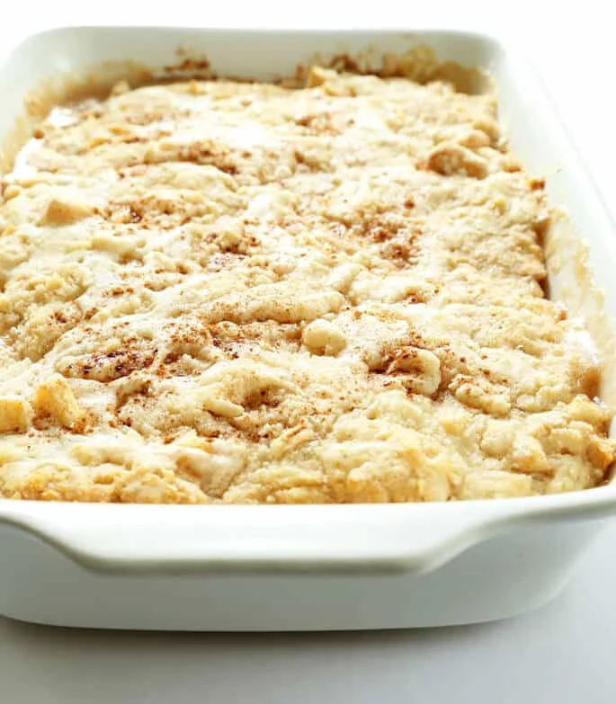 A white dish with apple "dump" cake