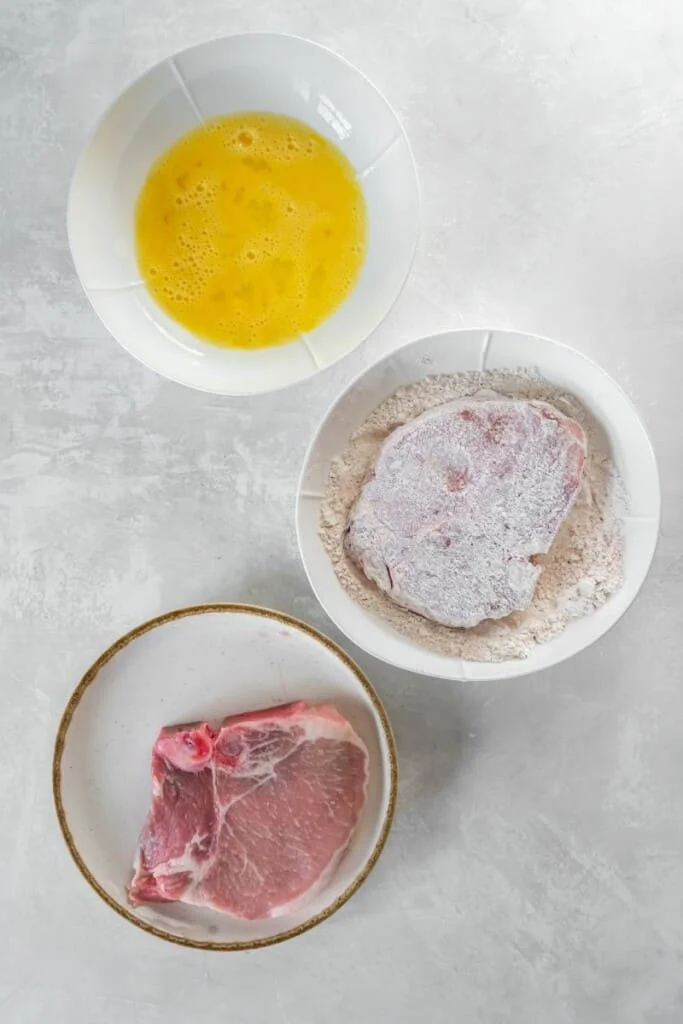 adding flour to pork chop