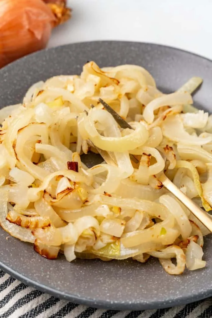 Air fried onions on a plate with a fork inside them.
