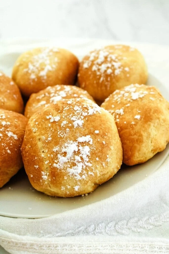 Air fried Oreos on a white plate with dusting sugar on top.