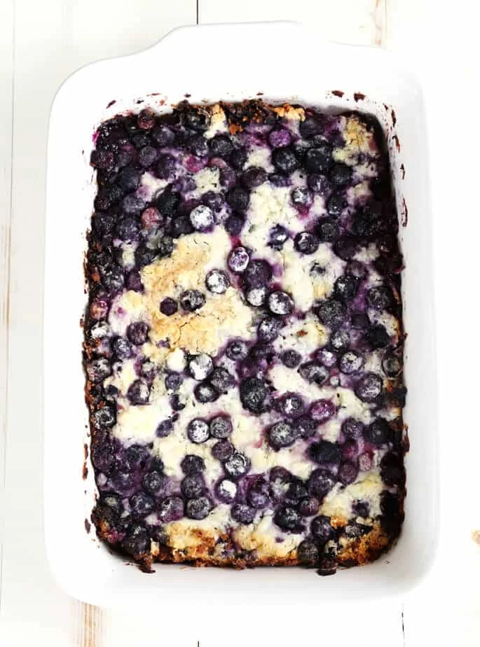 An overhead view of blueberry dump cake in a white dish