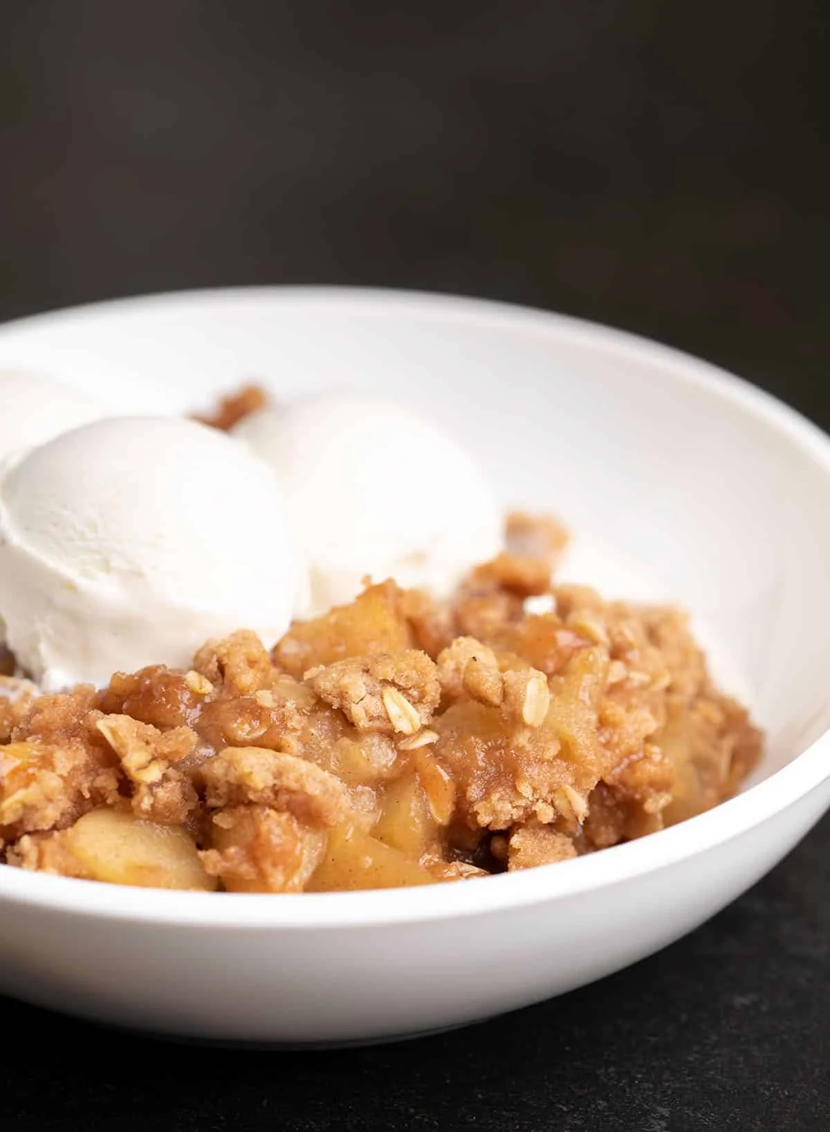 Baked apples and crisp topping with two scoops of vanilla ice cream.