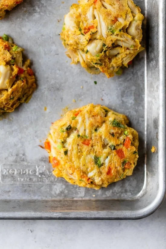Baked crab cakes on a baking sheet.