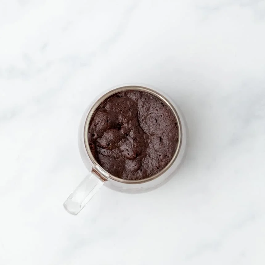 Baked gluten free mug cake with a rich texture, still in the glass mug.