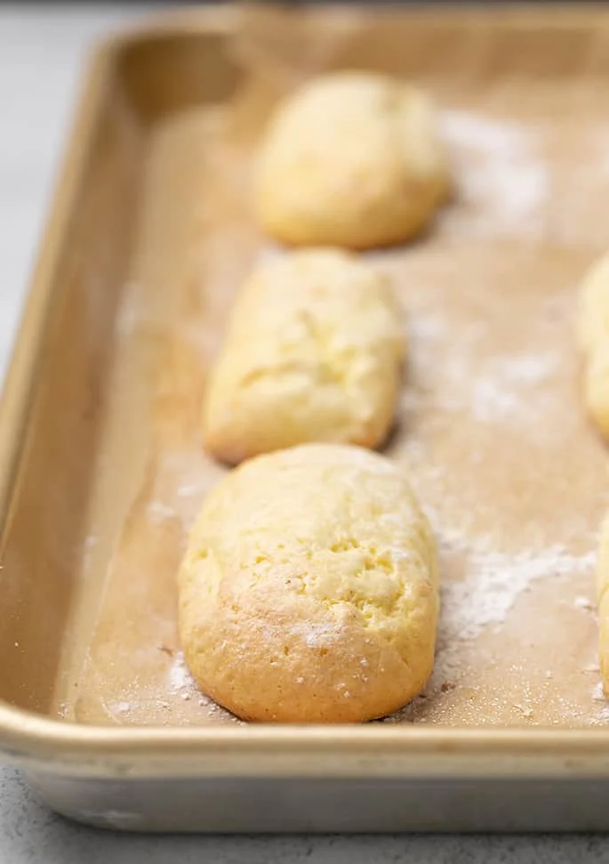 Baked ladyfingers on brown paper on tray
