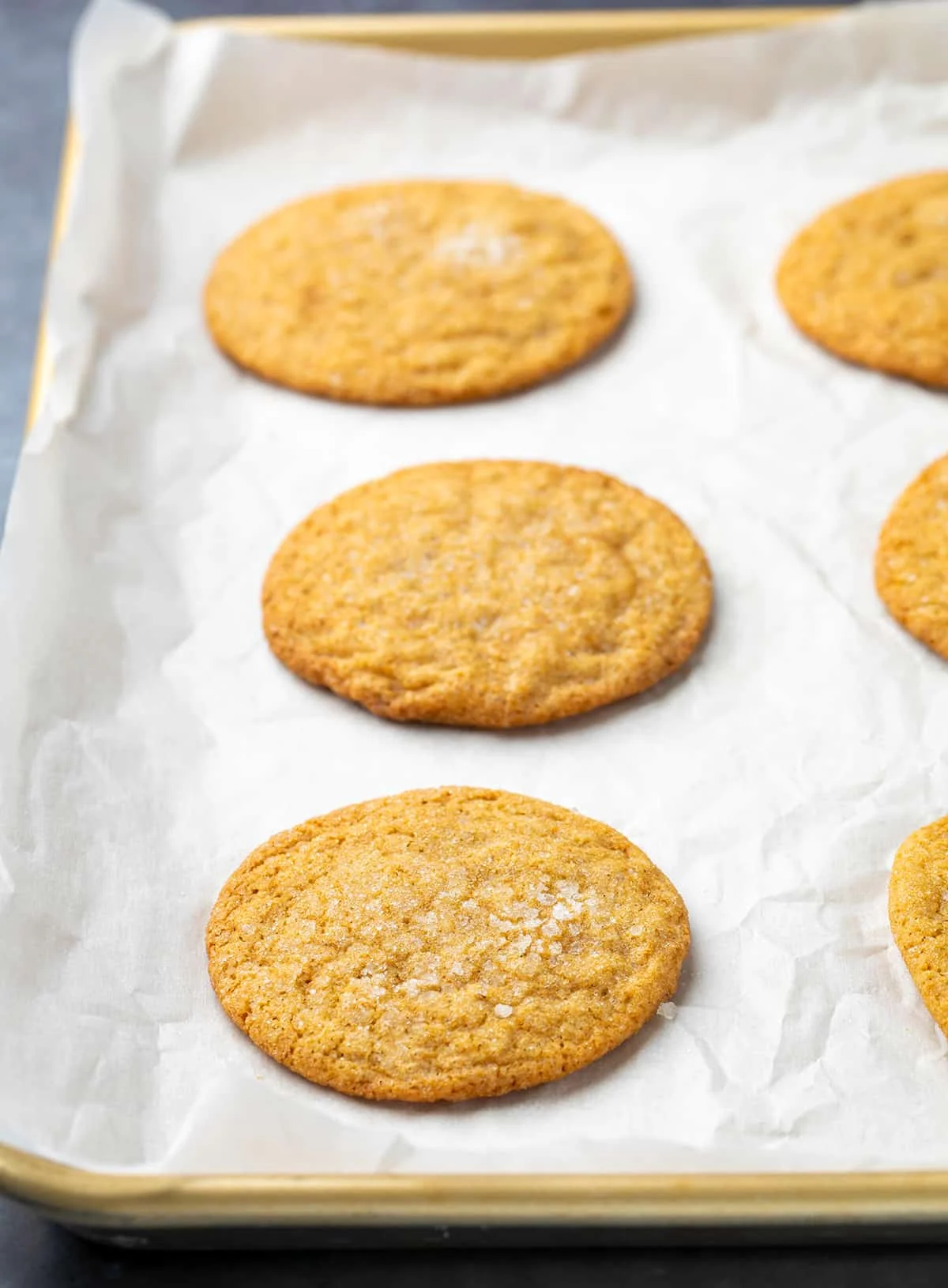 Baked soft ginger cookies on white paper on gold tray
