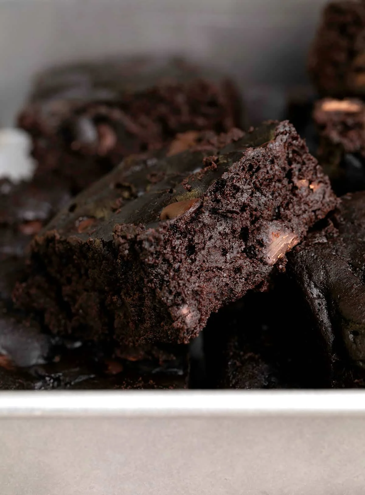 Black bean brownies in a pile in a metal baking pan