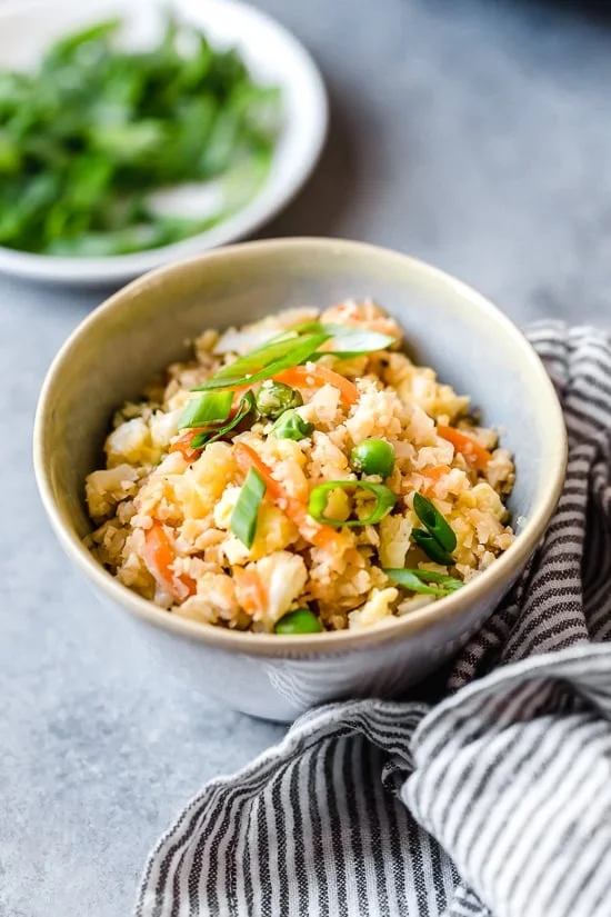 Bowl of cauliflower fried rice with scallions.