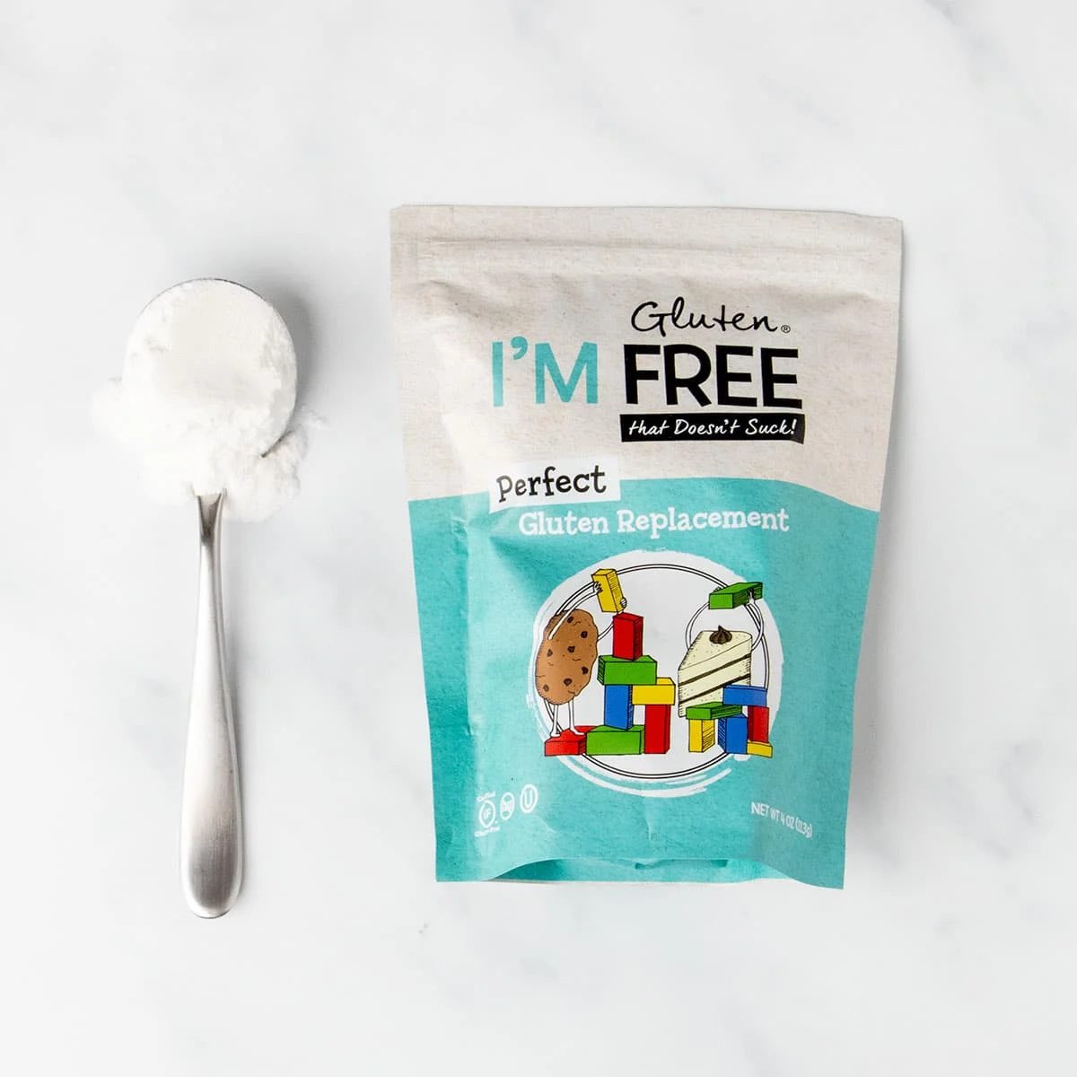bright blue and white package of perfect gluten replacement with sample of white powder on large metal spoon