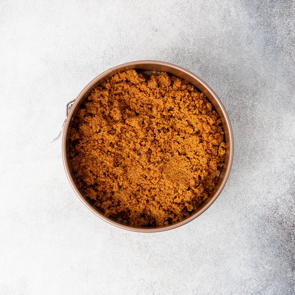 Brown clumps now in round gold colored springform pan.