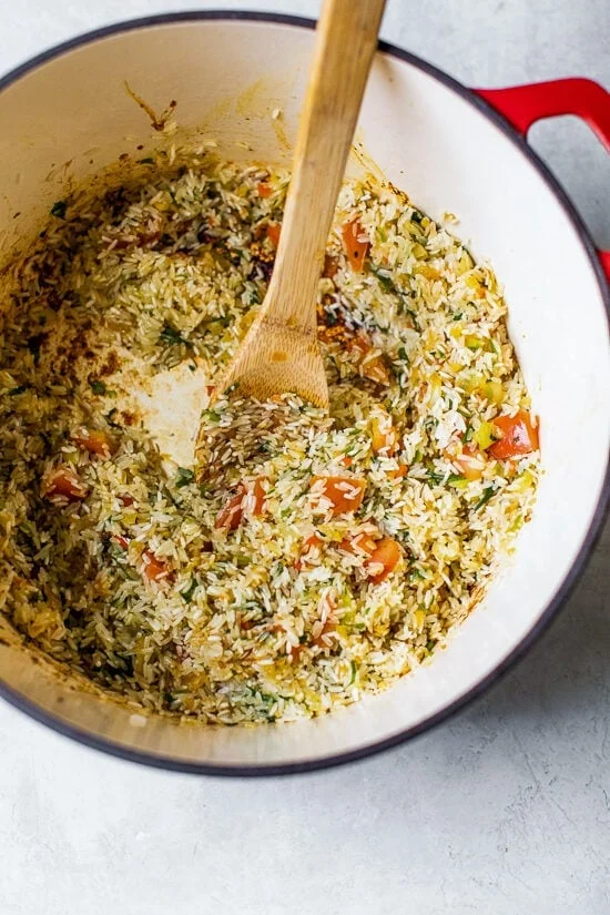 Browned rice and vegetables in a Dutch oven.