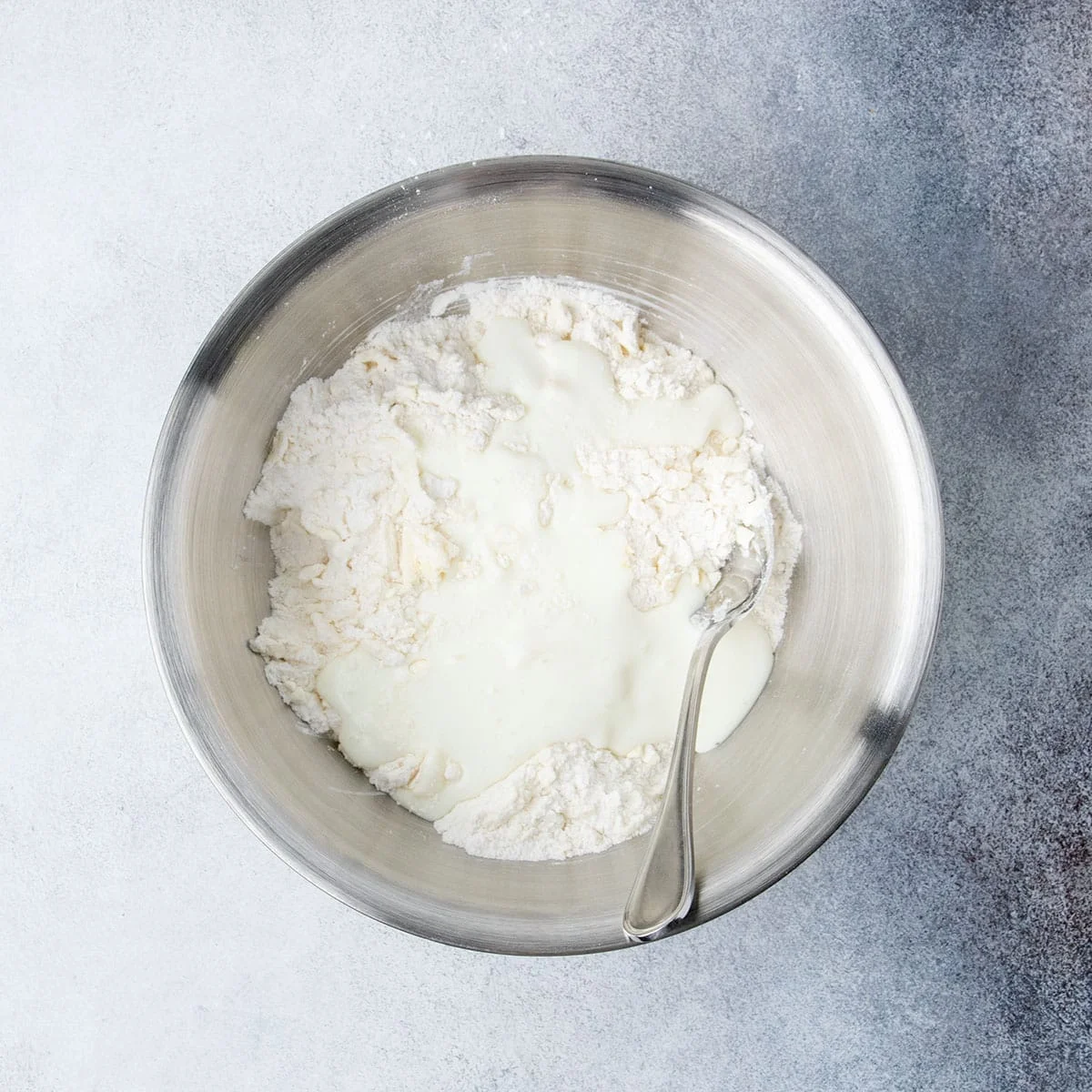 Buttermilk added to the flour and butter mixture in a large mixing bowl for the topping.