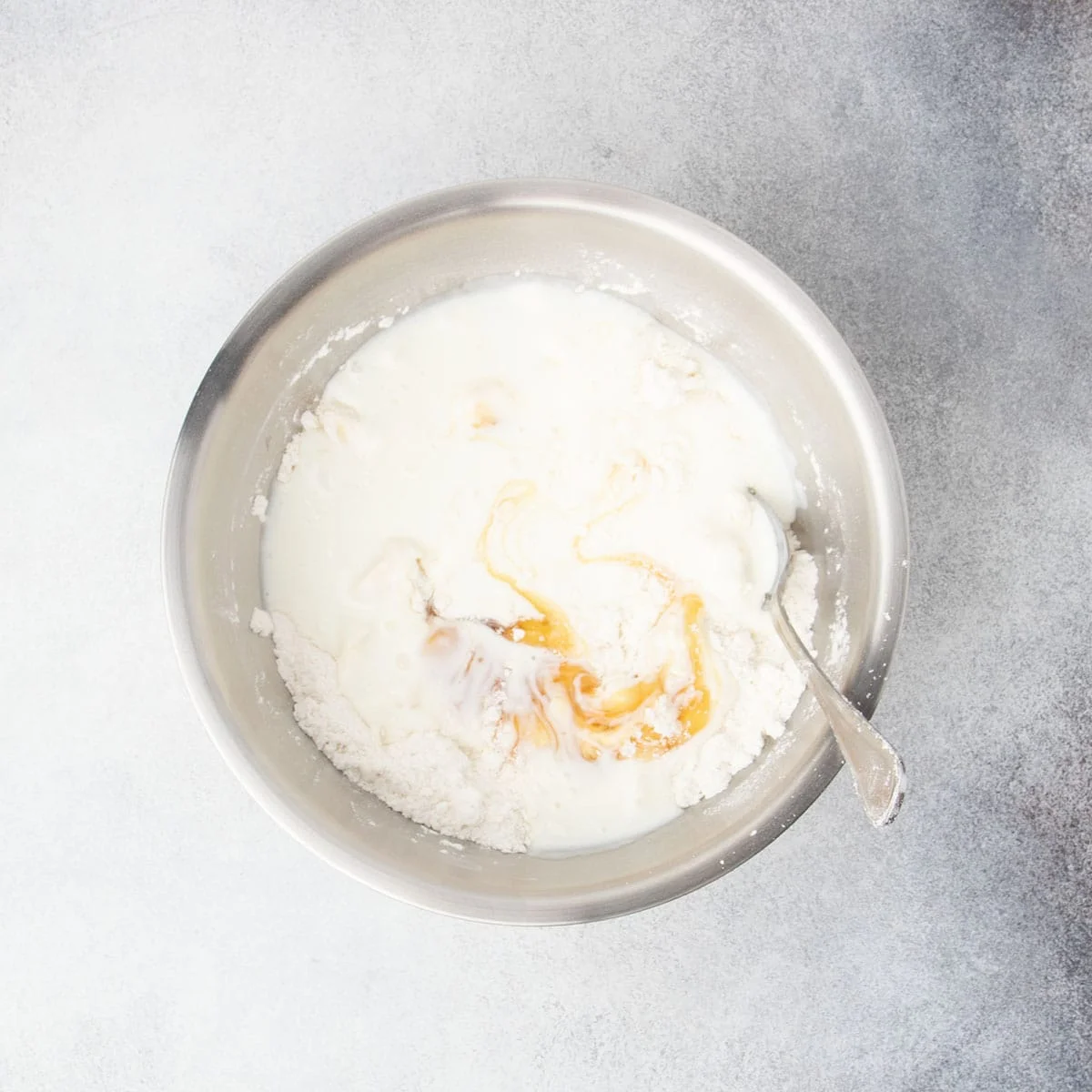 Buttermilk and honey added to gluten free flour mixture in a bowl before mixing.