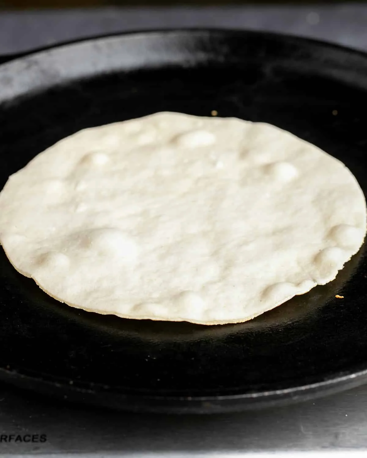 Cassava flour tortilla cooking on underside in skillet