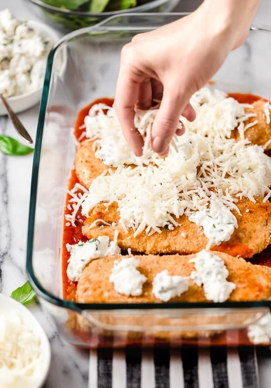 Cheese on top of chicken cutlets in a casserole dish