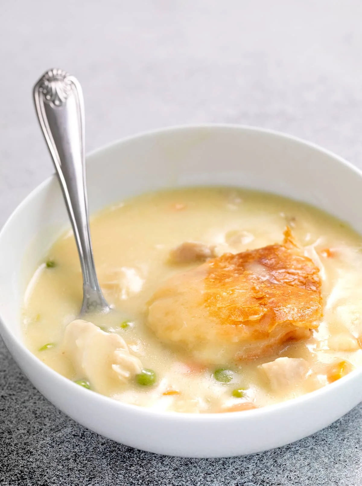 Chicken pot pie served in a small white bowl with a spoon