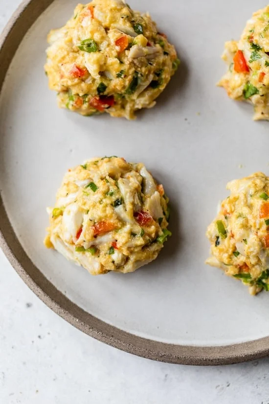 Chilled crab cake patties on a plate.