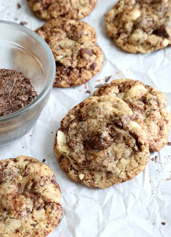 Chocolate chip cookies laying in each other on white surface.