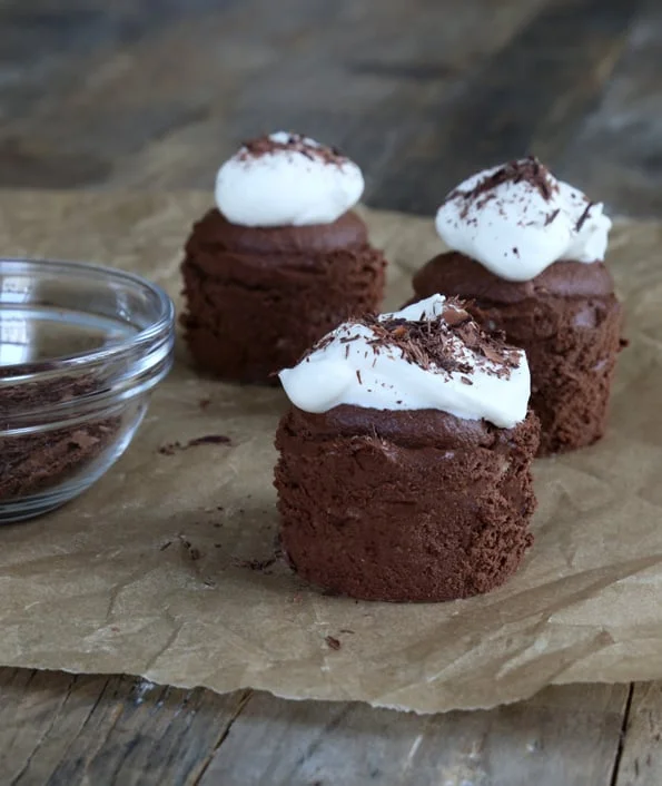 Chocolate cupcakes on brown surface.