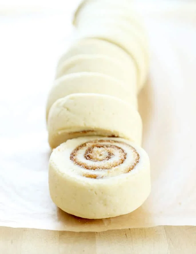 Cinnamon bun dough slices on brown surface 
