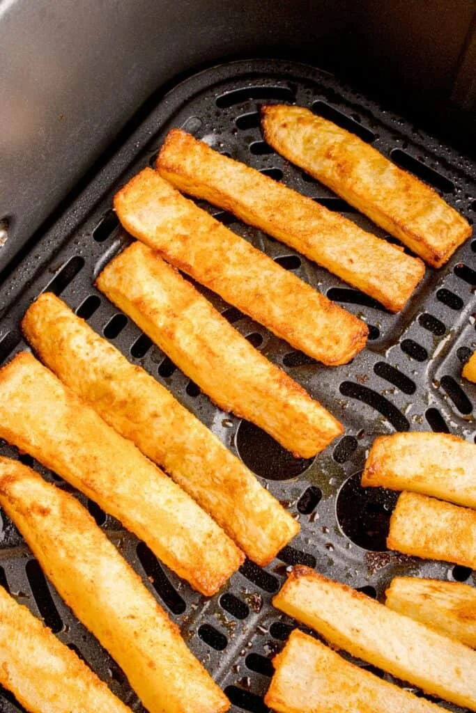 Close up of homemade french fries in an air fryer basket, cooked.
