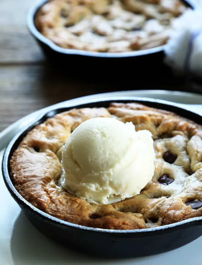Close up of pizookie with vanilla ice cream in black skillet