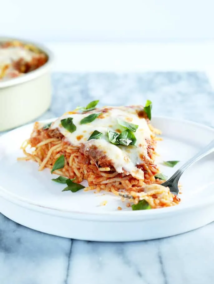 Close up of spaghetti pie on a white plate.