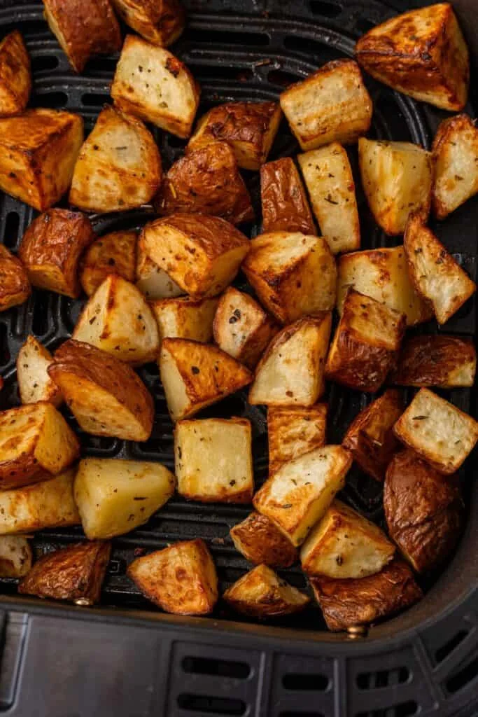 Close up of the air fryer red potatoes in the air fryer basket.