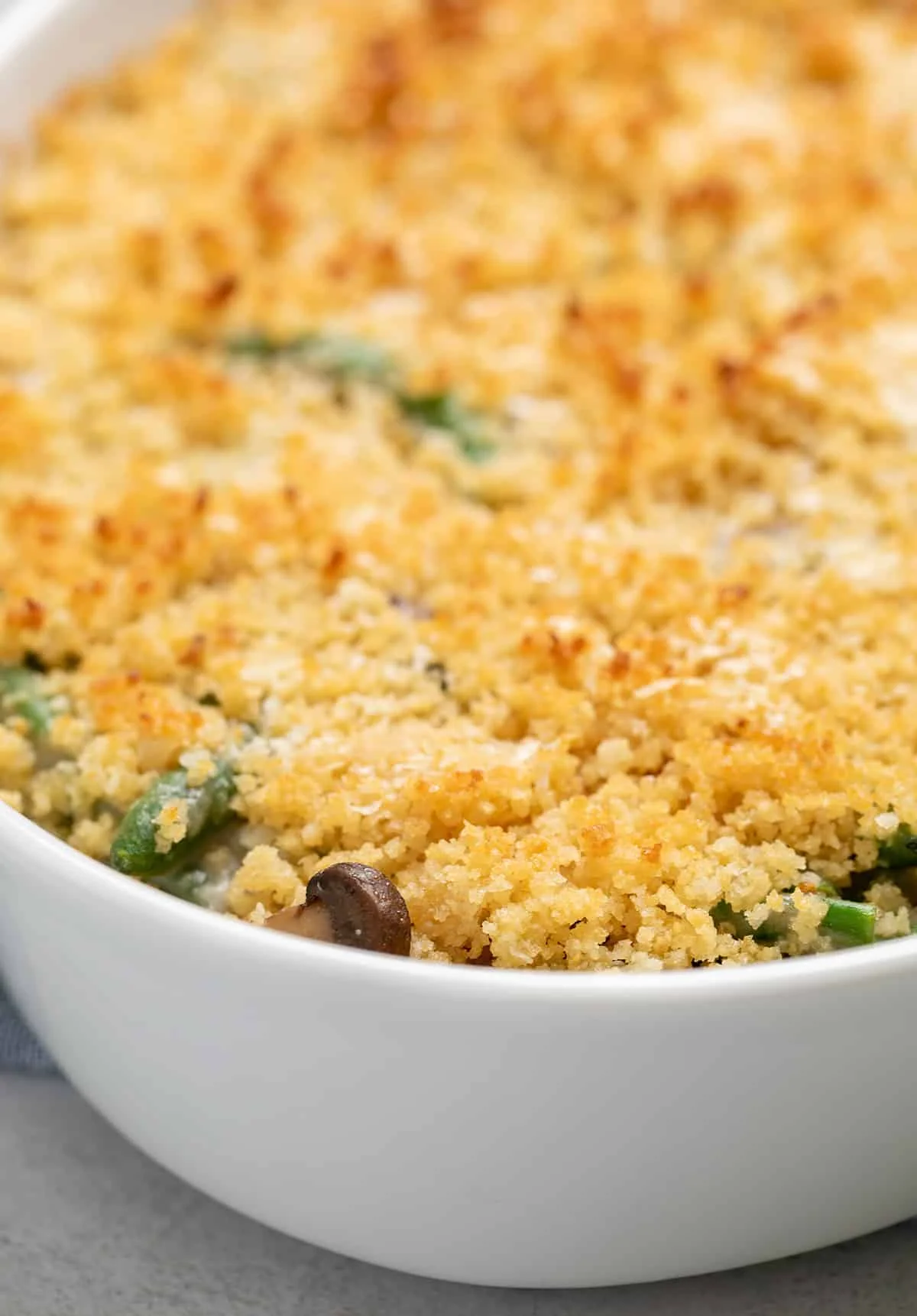 Closeup image of baked gluten free green bean casserole with browned breadcrumbs on top without crispy fried onions